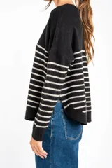 Sweater de tejido de punto color beige melange, con cuello redondo y mangas largas. Presenta rayas horizontales en tonos verde oliva, lila, marrón, naranja y rosado.