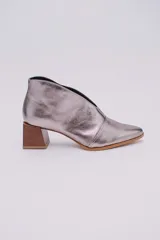 Botines de cuero color beige con diseño de tajo frontal, punta fina y taco cuadrado de madera.