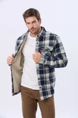Campera leñadora de viyela a cuadros en tonos beige y azul oscuro, con interior forrado en corderito, cierre frontal con botones y dos bolsillos con solapa en el pecho.