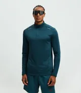 Remera deportiva de manga larga con cuello alto y cierre frontal parcial. Presenta una textura acanalada en toda la prenda y detalles reflectivos en los hombros.