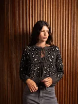 Saco de punto con estampado animal print, de corte recto y manga larga. Presenta cierre frontal mediante lazos ajustables y terminaciones en tejido acanalado.