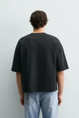 Sudadera de corte relajado confeccionada en algodón, con cuello redondo, manga corta y acabado en rib. Presenta un estampado gráfico a contraste en la parte frontal.
