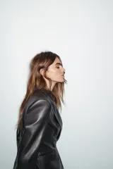 Blazer de corte cruzado confeccionada en material efecto piel, con cuello solapa, manga larga con hombreras, bolsillos delanteros con solapa y cierre frontal con botones.