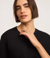 Blusa básica lisa de algodón color negro, con cuello redondo y mangas cortas, de corte clásico y versátil.