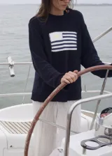 Sweater de punto color azul marino, con cuello redondo y diseño de la bandera de Uruguay tejida en el frente. Presenta un corte clásico con terminaciones acanaladas en puños y ruedo.