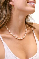 Collar corto elaborado con multipiezas de cristales en tonos rosados y cuentas facetadas translúcidas, con cierre de acero.