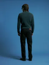 Pantalon denim de cinco bolsillos, corte recto y color negro, con botones y remaches metálicos en tono plata viejo.