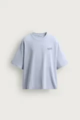 Camiseta boxy fit color celeste, con cuello redondo y manga corta. Cuenta con un pequeño estampado en el pecho con la inscripción "On Hold".