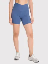 Calza corta tipo biker de tiro alto con pretina en V, color azul. Confeccionada en tejido técnico con bandas de silicona internas para mayor sujeción.