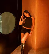 Conjunto de dos piezas compuesto por un top negro sin mangas con espalda descubierta y ajuste mediante tiras laterales, y un short negro de corte ajustado.