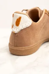 Zapatillas bajas color marrón con detalles en cuero con estampado de vaca en los laterales y talón.