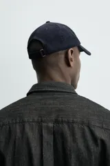 Gorra de seis paneles confeccionada en pana de algodón con visera curva y ajuste en la parte posterior.