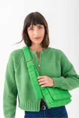 Cartera tipo bandolera acolchada de color verde brillante, con correa ancha y ajustable con hebilla metálica.