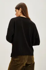 Sweater negro de manga larga con cuello redondo y tejido jacquard en dorado con diseño damasco.