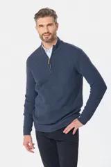 Buzo tejido azul marino con cuello alto y medio cierre frontal. Presenta una textura estructurada y manga larga.