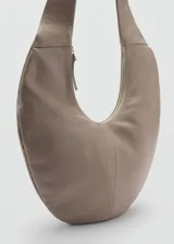 Bolso de hombro de cuero vacuno con diseño en forma de luna creciente, asa integrada ajustable y cierre de cremallera.