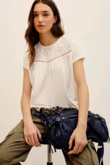 Remera blanca de manga corta, con canesú superior de broderie y detalles ajurados.
