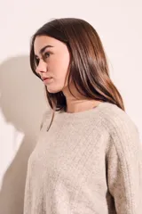 Sweater color visón de punto texturado, corte holgado y cuello redondo.