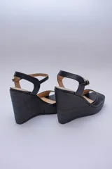 Sandalias negras de cuero con plataforma y tacón corrido cubierto en rafia.