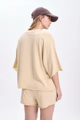 Remera de manga corta color amarillo con efecto lavado, corte oversize y terminaciones sin dobladillo.