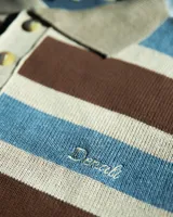 Buzo tejido de punto grueso con diseño de rayas horizontales en tonos marrón, azul y beige. Presenta cuello polo con cierre de tres botones, puños y cintura en canalé, y logo bordado en el pecho.