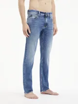 Pantalón de jean azul de corte slim fit, tiro bajo, con lavado vintage y diseño de cinco bolsillos.