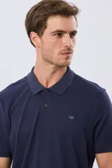 Remera polo de manga corta en color azul melange, con cuello camisero, cierre frontal de dos botones y pequeño bordado en el pecho.
