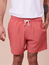 Short de baño color ladrillo con rayas verticales en relieve, cintura elástica con cordón ajustable y bolsillos laterales.