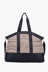 Maxi bolso color topo y negro, tipo shopper, con diseño acolchado y pespuntes. Cuenta con doble asa de hombro de cinta negra con la marca estampada y correa ajustable extraíble.