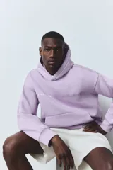 Buzo canguro lila con capucha, corte holgado, hombros caídos, bolsillo delantero y puños y bajo acanalados. Estampado con la frase "Paris, France" y "Le Triangle d'Or".