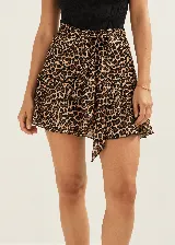 Minifalda de corte evasé con estampado animal print de leopardo, talle alto con lazo ajustable en la cintura y detalle de volados escalonados.