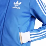 Chaqueta deportiva Adidas Beckenbauer color celeste con cuello, puños y ruedo blancos. Presenta cierre frontal, bolsillos laterales con cierre y las tres líneas características de la marca en color blanco sobre las mangas.