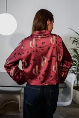 Camisa bordó de satén con estampado personalizado, cuello camisero, cierre frontal con botones y mangas largas con puños rectos.