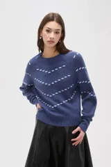 Sweater de punto color azul con diseño de fantasía en forma de líneas curvas punteadas en color celeste. Presenta cuello redondo a la base, mangas largas con puños acanalados y corte holgado.