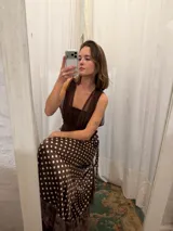 Pollera midi tipo pareo de satén color chocolate con estampado de lunares blancos. Presenta un diseño envolvente con ajuste lateral y un ruedo con detalle de microtul y puntilla bordada.