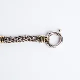 Gargantilla de cadena de eslabones entrelazados en plata 925 con detalles en oro, destacada por un cierre marinero frontal circular.