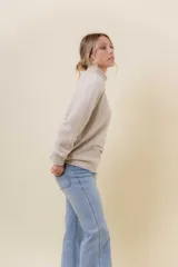 Polera de tejido de punto con textura marcada, cuello alto y diseño oversize con hombros caídos y terminaciones acanaladas.