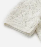 Camisa polo blanca de manga corta con cuello y tejido de punto con textura calada en forma de rombos.