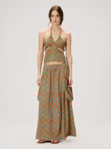 Falda midi de tiro alto y silueta evasé, confeccionada en algodón con diseño estampado geométrico en tonos verdes, naranjas y celestes. Cuenta con caída fluida, ruedo ligeramente acampanado y dos bolsillos cuadrados laterales.