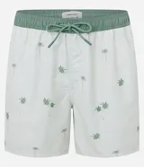 Bermuda de baño para hombre confeccionada en microfibra ligera, color blanco, con una estampa sutil de cocoteros en tonos verdes/azulados. Presenta cintura elástica con cordón de ajuste contrastante en color verde, y bolsillos laterales.