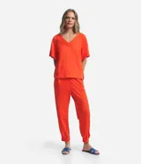 Blusa de manga corta color naranja, confeccionada en tejido Orly, con escote en V con detalle de costuras trabajadas.