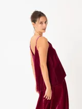 Top negro de terciopelo con breteles finos regulables y escote en V. La parte trasera es más larga que la delantera.