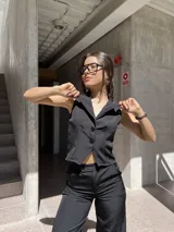 Chaleco negro de tela barbie con corte sastrero y calce al cuerpo.