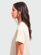Remera de algodón de manga corta en color crema, con cuello redondo y logo de la marca aplicado en la manga.