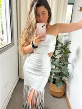 Vestido plateado sin mangas, con escote recto, corte ajustado y falda midi con flecos.