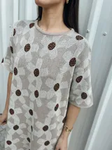 Vestido corto beige con estampado de flores marrones, corte holgado y mangas cortas.