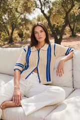 Cardigan de punto con diseño de crochet a rayas en color marrón y beige, con cuello polo, mangas cortas y cierre frontal con botones.
