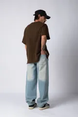 Jean de corte baggy con diseño amplio y holgado, confeccionado en denim de lavado claro con efecto desgastado en las piernas.