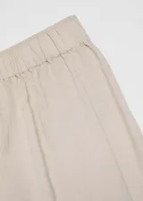 Pantalon de corte wideleg y diseño crop, confeccionado en una mezcla de lino y viscosa. Presenta cintura con elástico y dos bolsillos laterales.