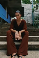 Pantalón palazzo de tiro medio en color marrón, confeccionado en tejido con textura. Cuenta con cintura elástica ajustable mediante cordones y diseño de pierna ancha.